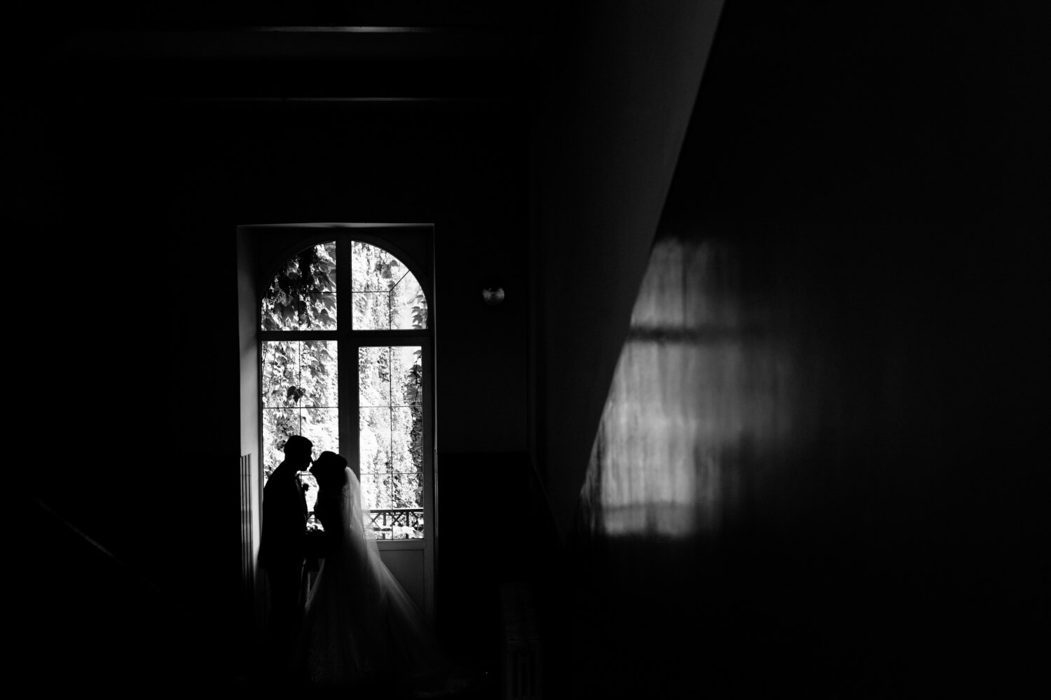 monochrome-view-silhouette-wedding-couple-which-is-nearly-kissing-near-window-jpg